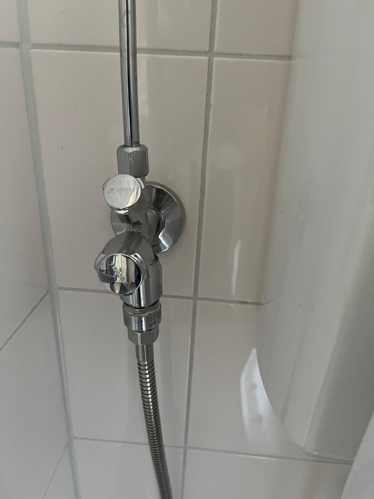 De geplaatste hoekstopkraan met aansluiting voor de handdouche in het toilet in Delft
